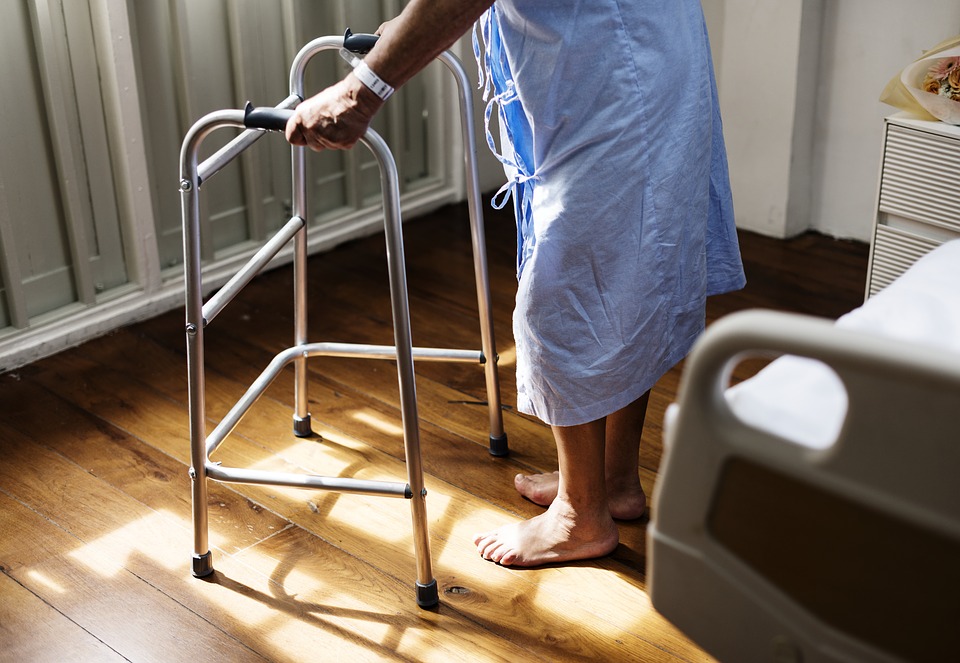Patient in hospital gown using walker