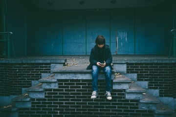 Boy sitting on wall alone