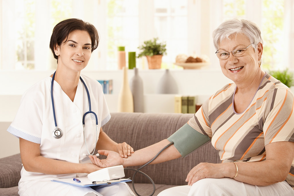Nurse taking elderly patient's blood pressure