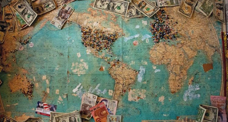 world map surrounded by currency notes