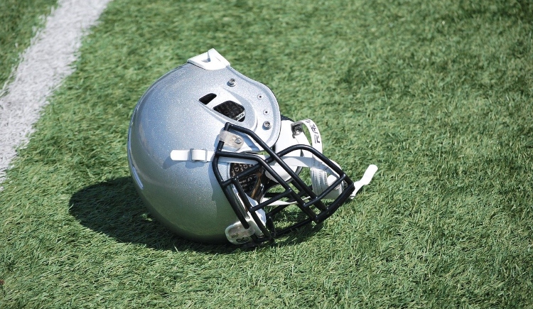 Football helmet on field Image by andzelikatokarska from Pixabay 