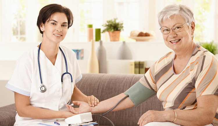 Nurse taking elderly patient's blood pressure
