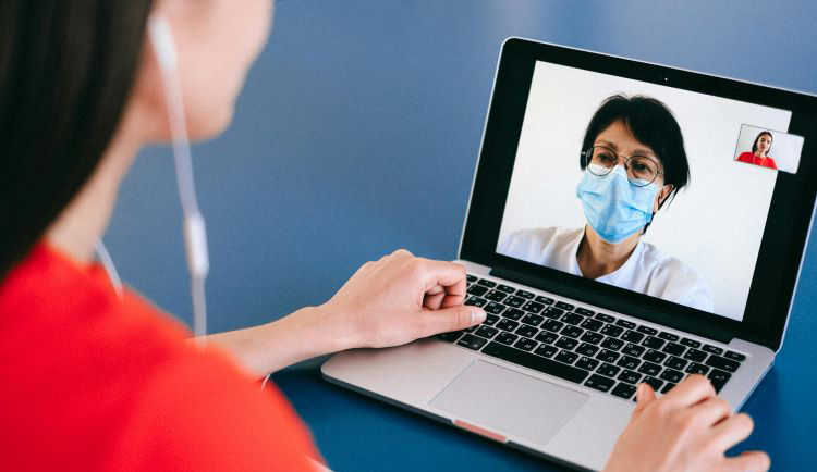 Woman talks to doctor on screen via telehealth appointment