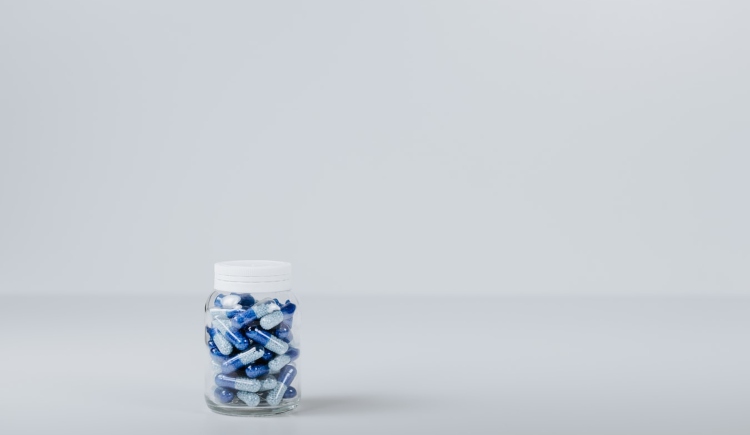 blue and white tablets in clear jar