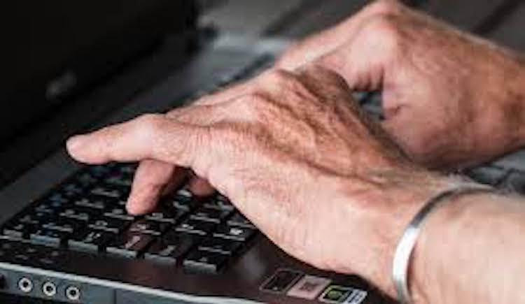 Hands typing on laptop keyboard